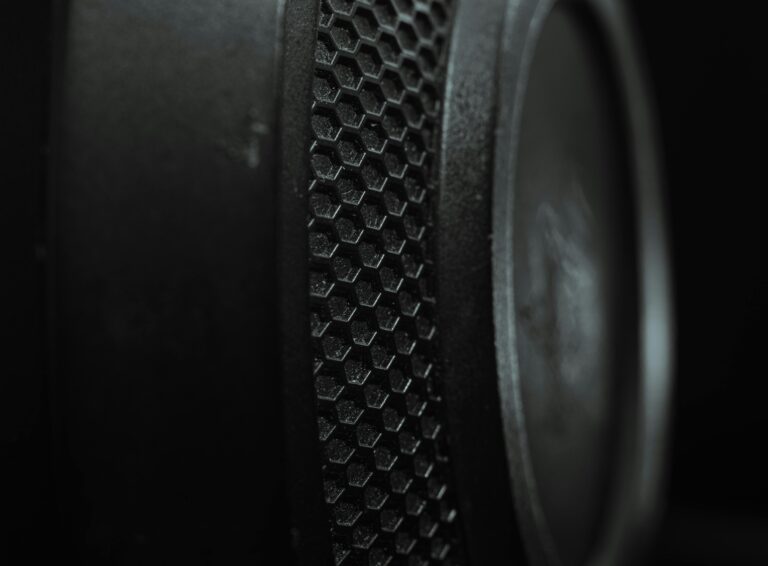 Detailed macro shot of a speaker with a hexagonal textured pattern and a dark tone.